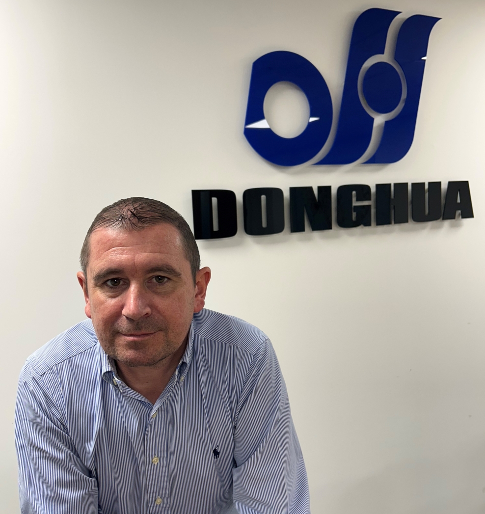 Photo of Michael Turta in front of Donghua sign